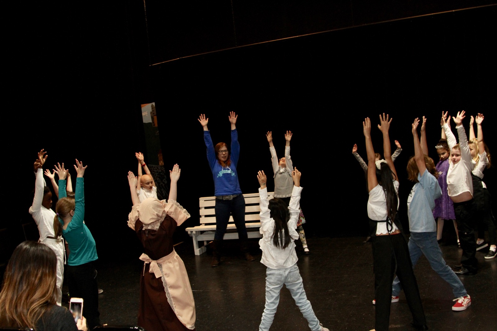 A picture of students warming up with Charlotte Forcht, Resident Director at North Texas Performing Arts