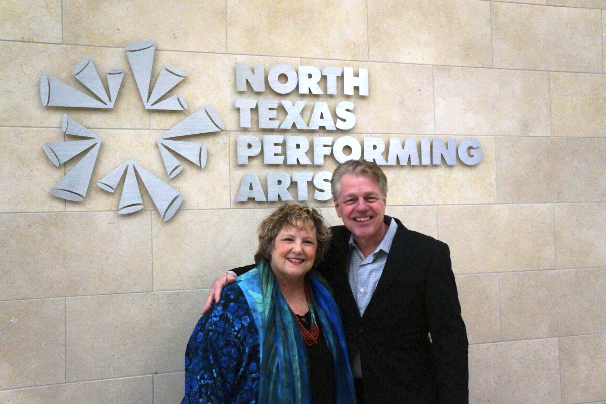 Sara Akers and Darrell Rodenbaugh stand in front of North Texas Performing Arts sign