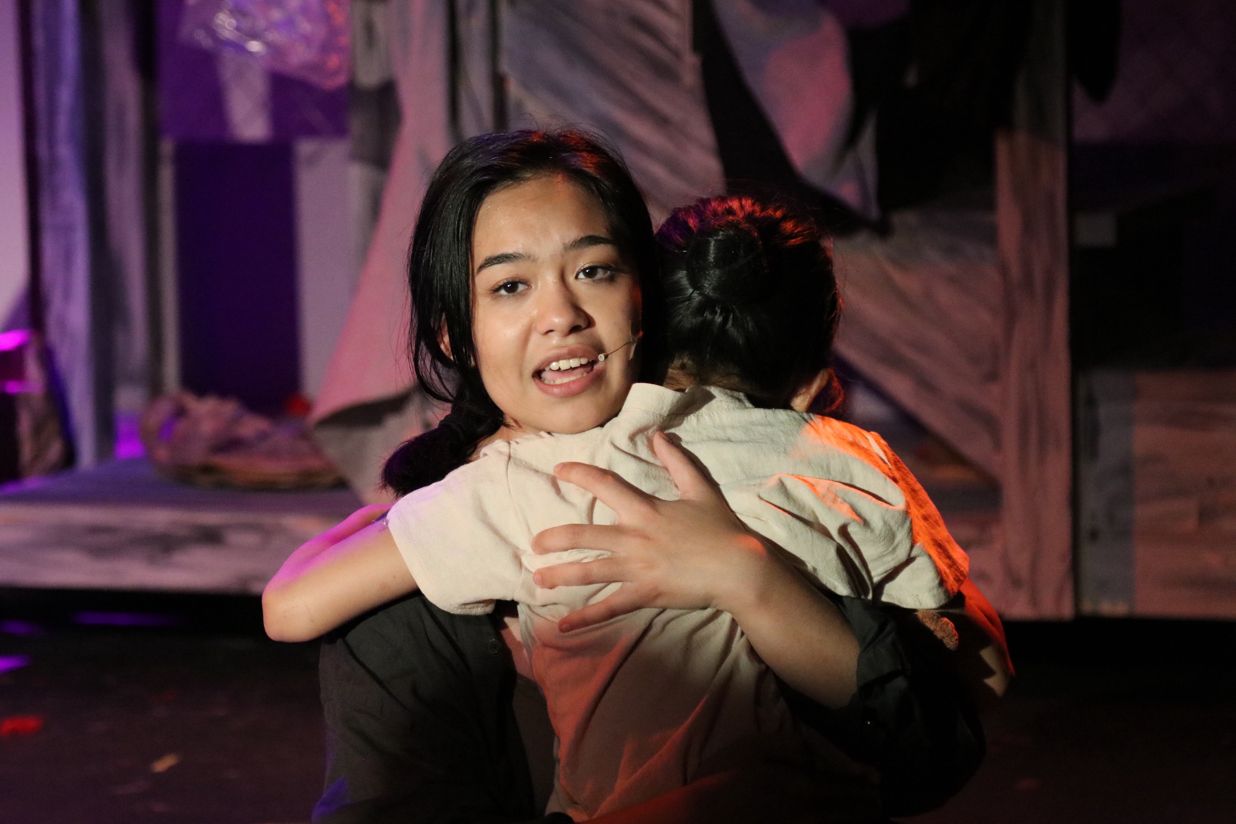 Actors hug on stage in performance of Miss Saigon