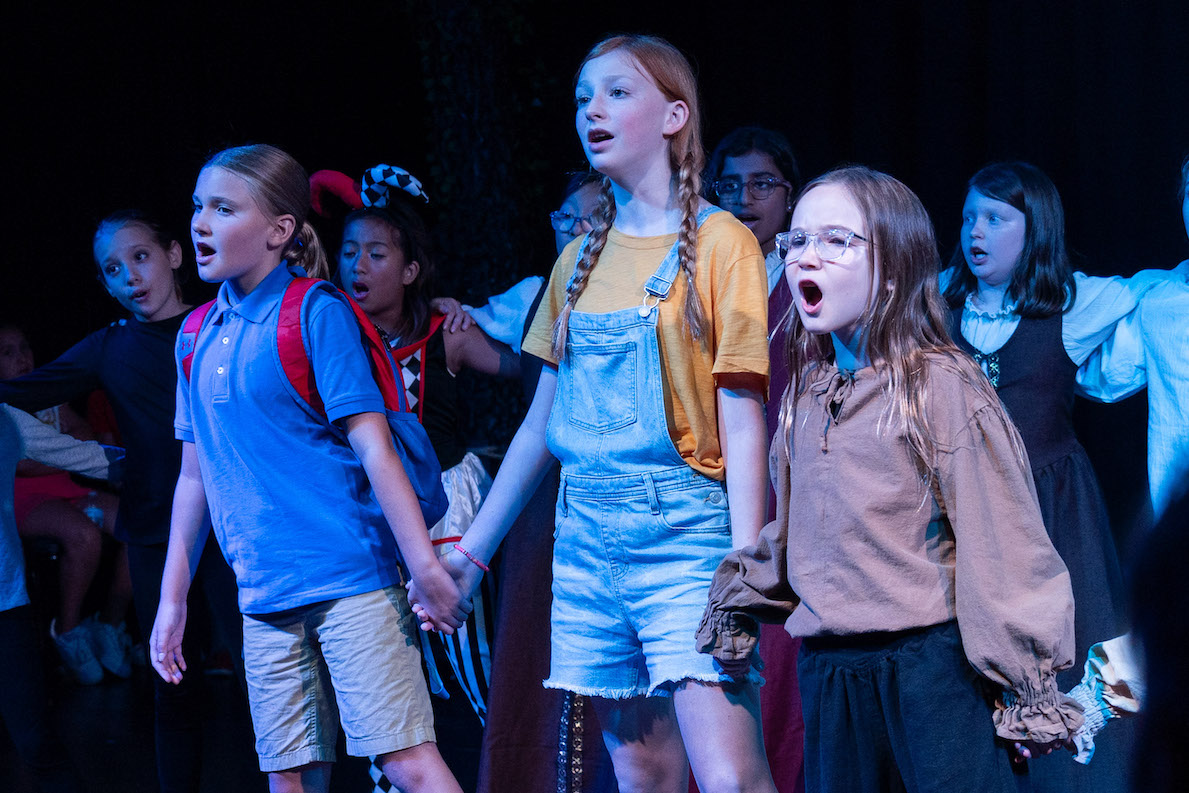 Three NTPA Fairview Actresses sign on stage during a 2023 production