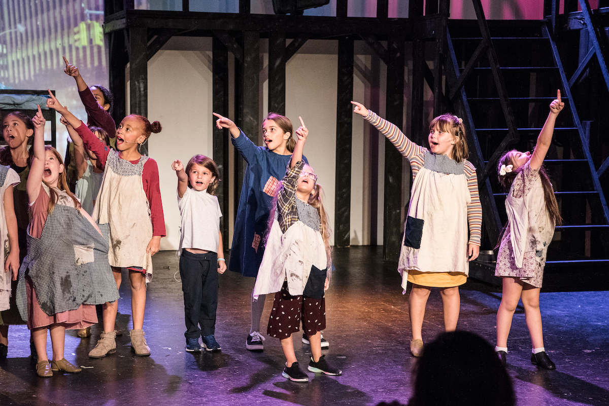 NTPA Southlake actors point to the sky while performing on stage in Annie 2023